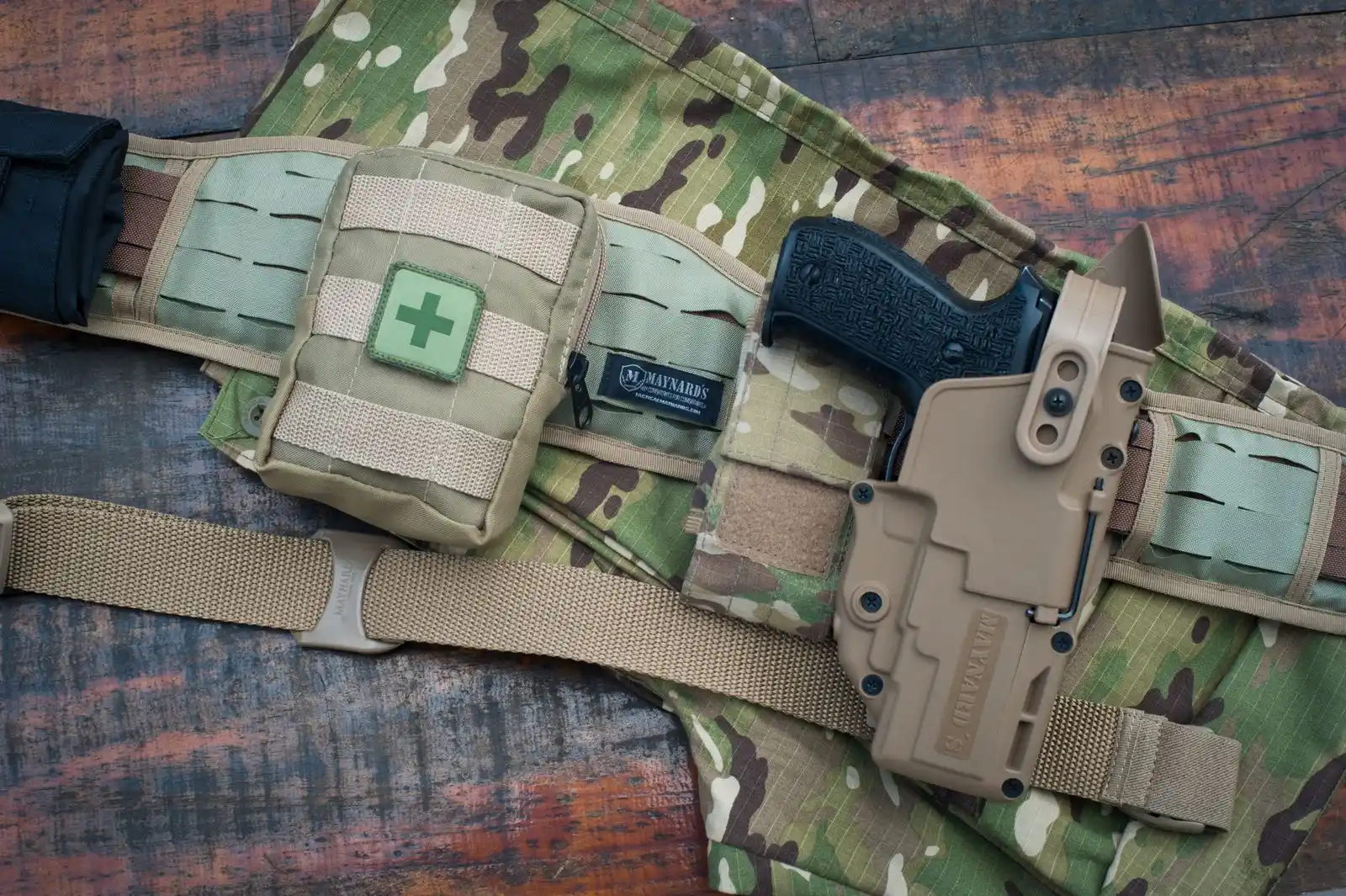 Tactical belt with holster laid out on camouflage fabric