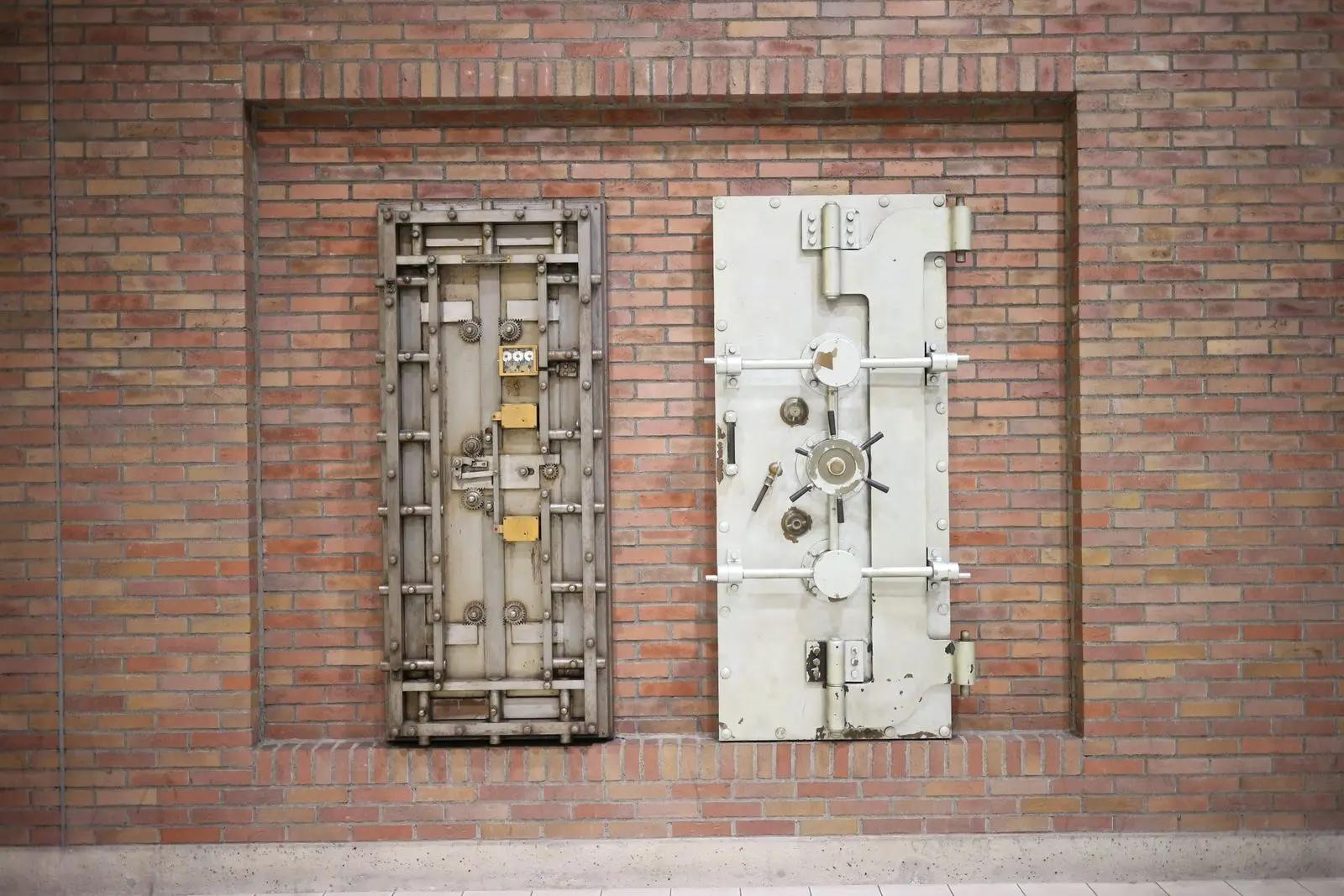 Heavy steel vault doors against a brick wall